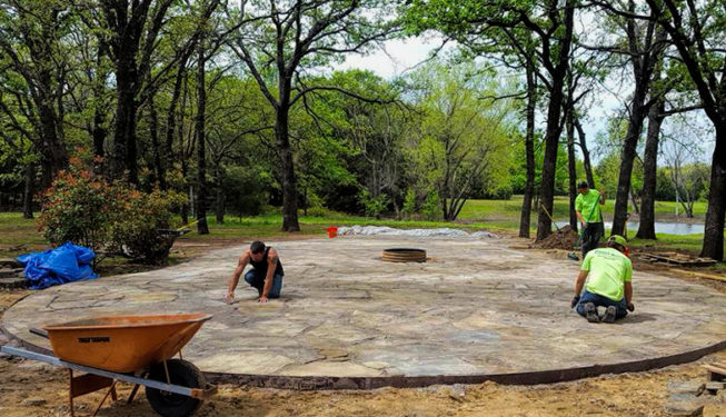 workers laying flagstone sitting area